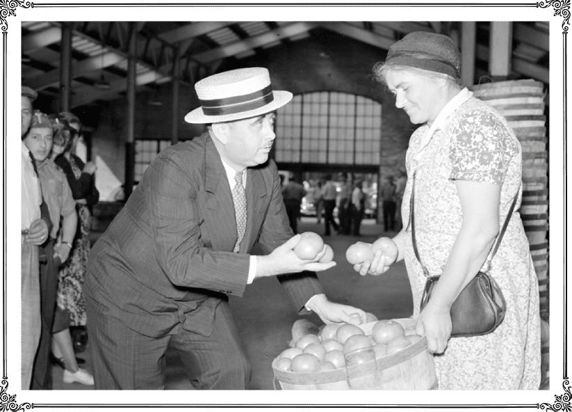 A man and woman are looking at apples.